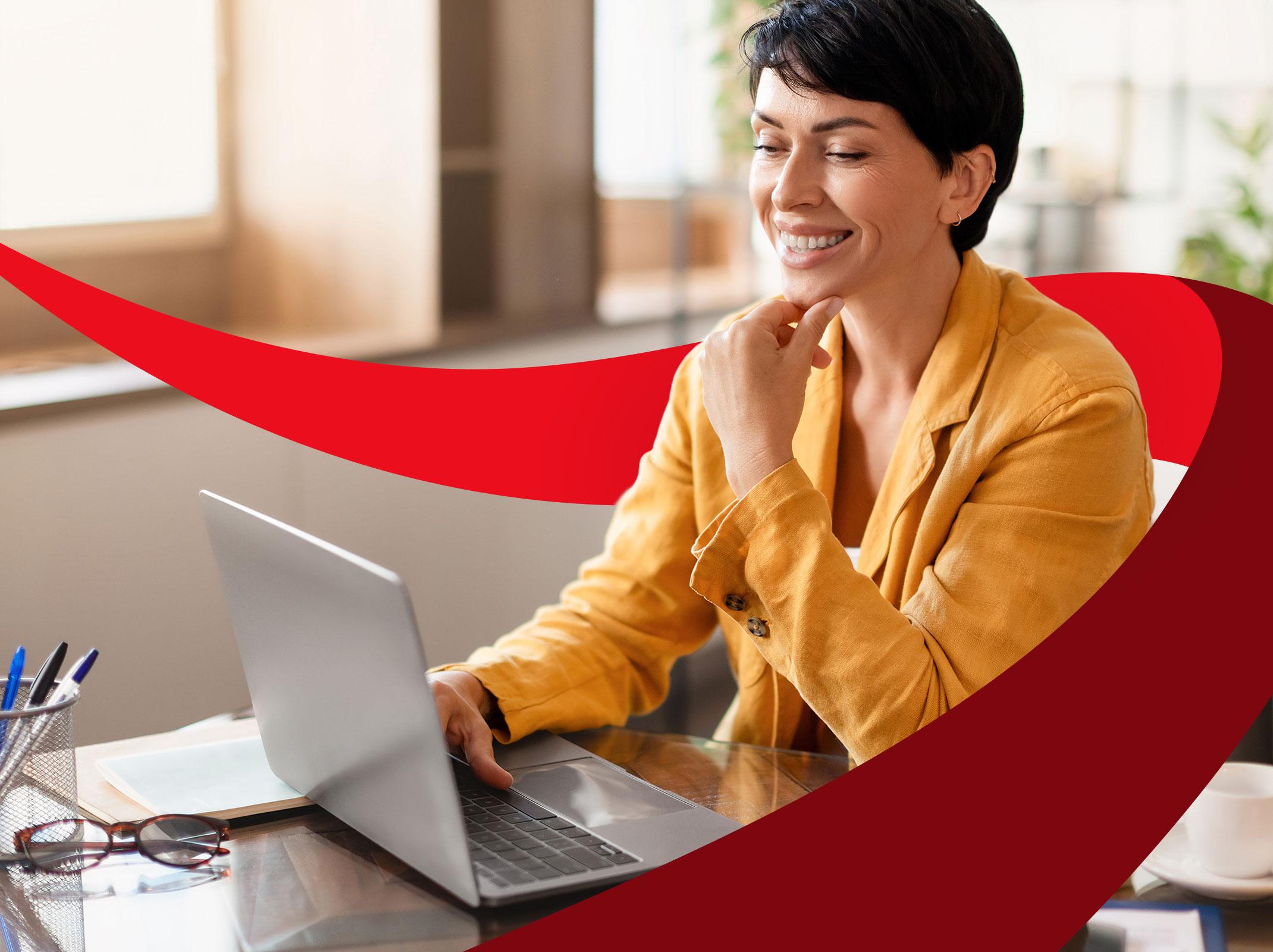 Woman smiling and using laptop in the office