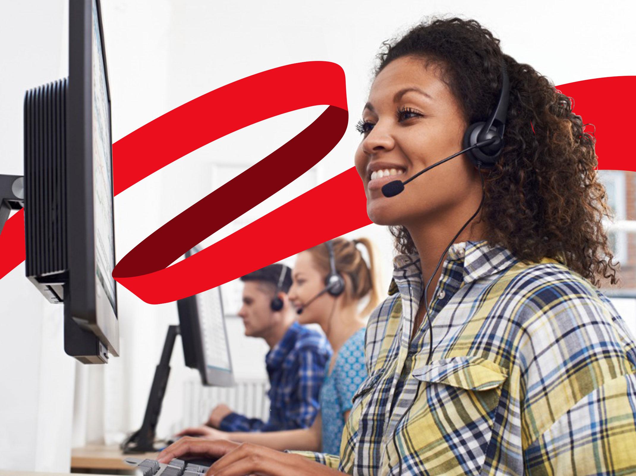 Customer service representative on headset in front of computer screen